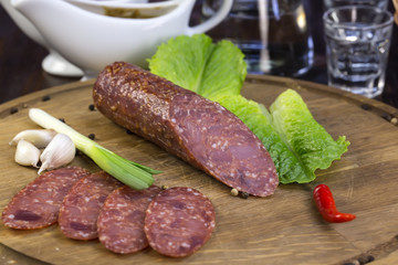 sausages on a wooden plate with vegetables in a restaurant