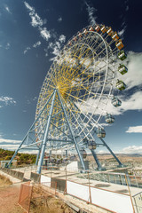 Ferris wheel on a background of blue sky