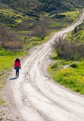 Teenage girl walking in a country dirt road