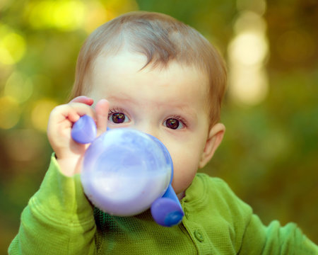 Baby drinking milk out of a sippy cup