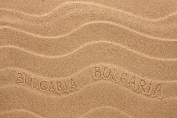 Fototapeta na wymiar Bulgaria inscription on the wavy sand