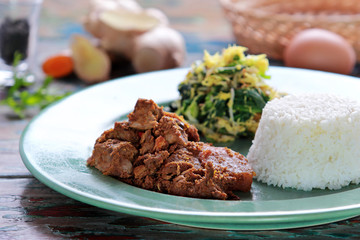 beef rendang served with urap and rice