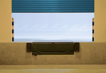 Dock leveler or height adjustable platform outside warehouse or industrial building. Used as bridge...