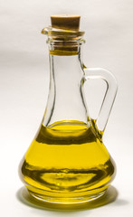 Vegetable oil in a bottle decanter on a white background