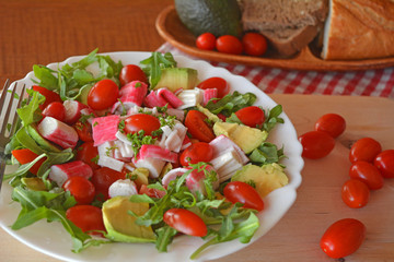 Mixed vegetable salad with crab sticks and avocado