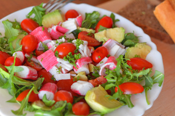 Mixed vegetable salad with crab sticks and avocado