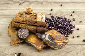 Marinated rack, ear, foot of pig and red edible bean over wood.