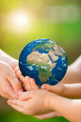 Children holding Earth planet in hands