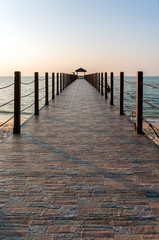 Fototapeta premium Concrete jetty heading towards the sea at sunset