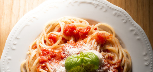 dish with spaghetti and tomato sauce on the wooden table