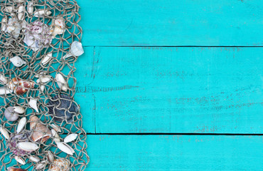 Seashells and fish net border on blank teal blue wood sign