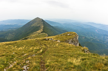 Rocks and cliffs under dark clouds trekking path at Suva Planina