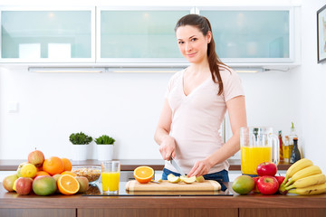 Young woman in the kitchen prepare fruits for breakfast. III