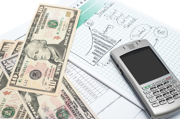 Cellphone and money on a notepad. Background image for finance