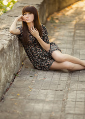 Fototapeta na wymiar Portrait of a beautiful young woman in dress in urban background