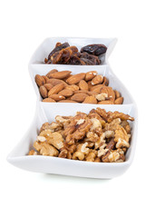 Walnuts almonds and dates in a white dish
