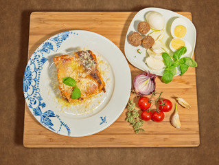 Lasagna con ingredienti su tagliere di legno