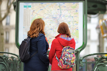 Obraz premium Two woman looking at the map of metro