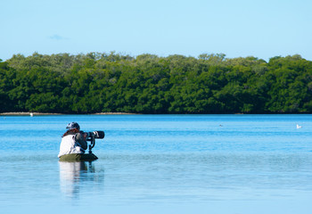 Fototapeta na wymiar Professional female nature photographer in water