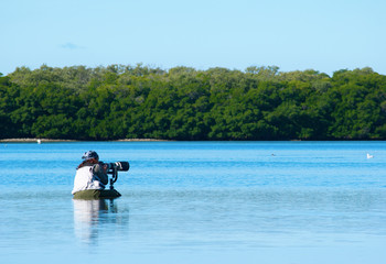 Professional female nature photographer in water