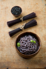 Black rice vermicelli over rustic wooden background, studio shot
