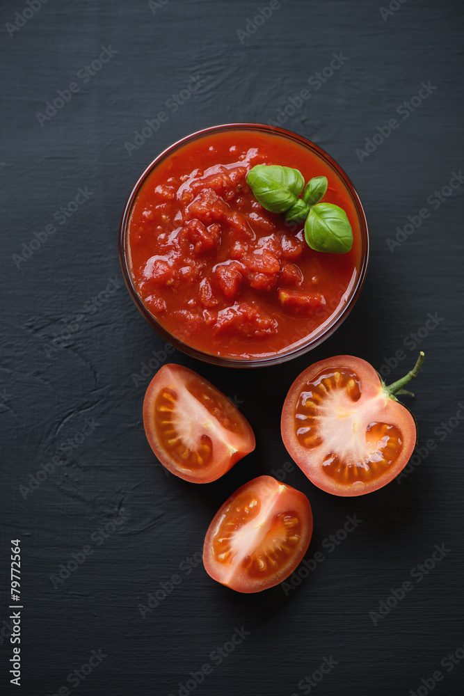 Poster Above view of chopped tomatoes, black wooden background