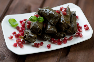 Dolmades with pomegranate on a glass plate, studio shot