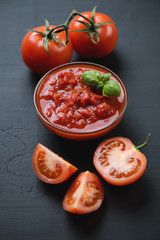 Close-up of chopped tomatoes, black wooden surface, studio shot