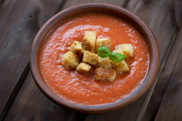 Ceramic bowl with Gazpacho, rustic wooden background, close-up