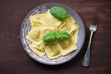 Ravioli with ricotta and spinach, dark wooden background