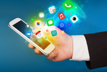 Hand holding smartphone with colorful app icons