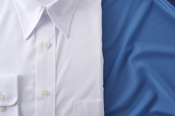 青い布の上に置いてある白いシャツ
