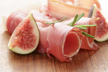 canapes with jamon and figs on wooden board