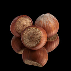 three hazelnuts on mirror, isolated