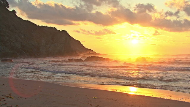 Sunrise over the sea on the beach rocks