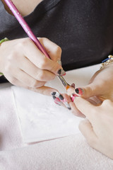 manicurist applying nail extensions