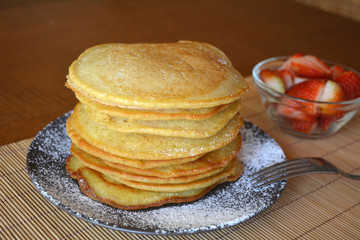 Stack of sweet pancakes with strawberry and icing sugar