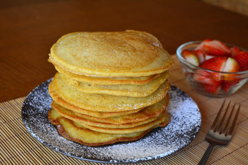 Stack of sweet pancakes with strawberry and icing sugar