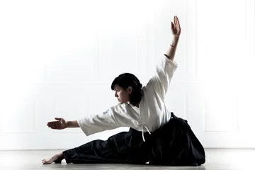 Foto op Plexiglas mooie vrouw die een hakama draagt die zich bezighoudt met kungfu 1 © operator1975