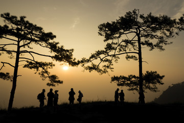 silhouette people on mountain at sunrise