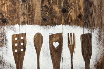 Cutlery old wooden table sprinkled with flour.