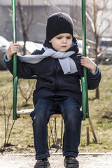 sad little boy on a swing