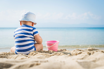 Fototapeta na wymiar Little baby boy sitting on the sand