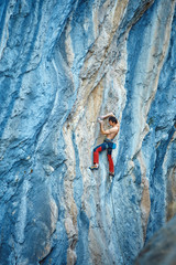 Rock climber climbing up a cliff