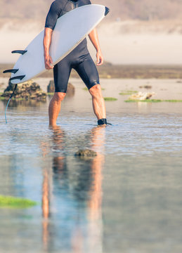 Surfer with surfboard on a coastline