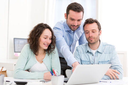 Two interns working together assisted by their course supervisor