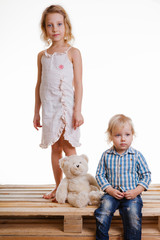 Little brother and sister playing together in a bright room