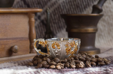 Cup of coffee on the background of coffee-mill