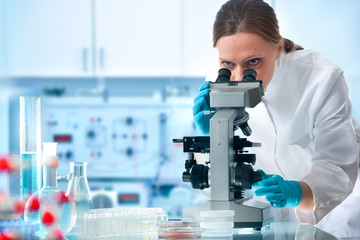 Scientist looking through a microscope in a laboratory