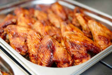 Grilled chicken wings in stainless steel container